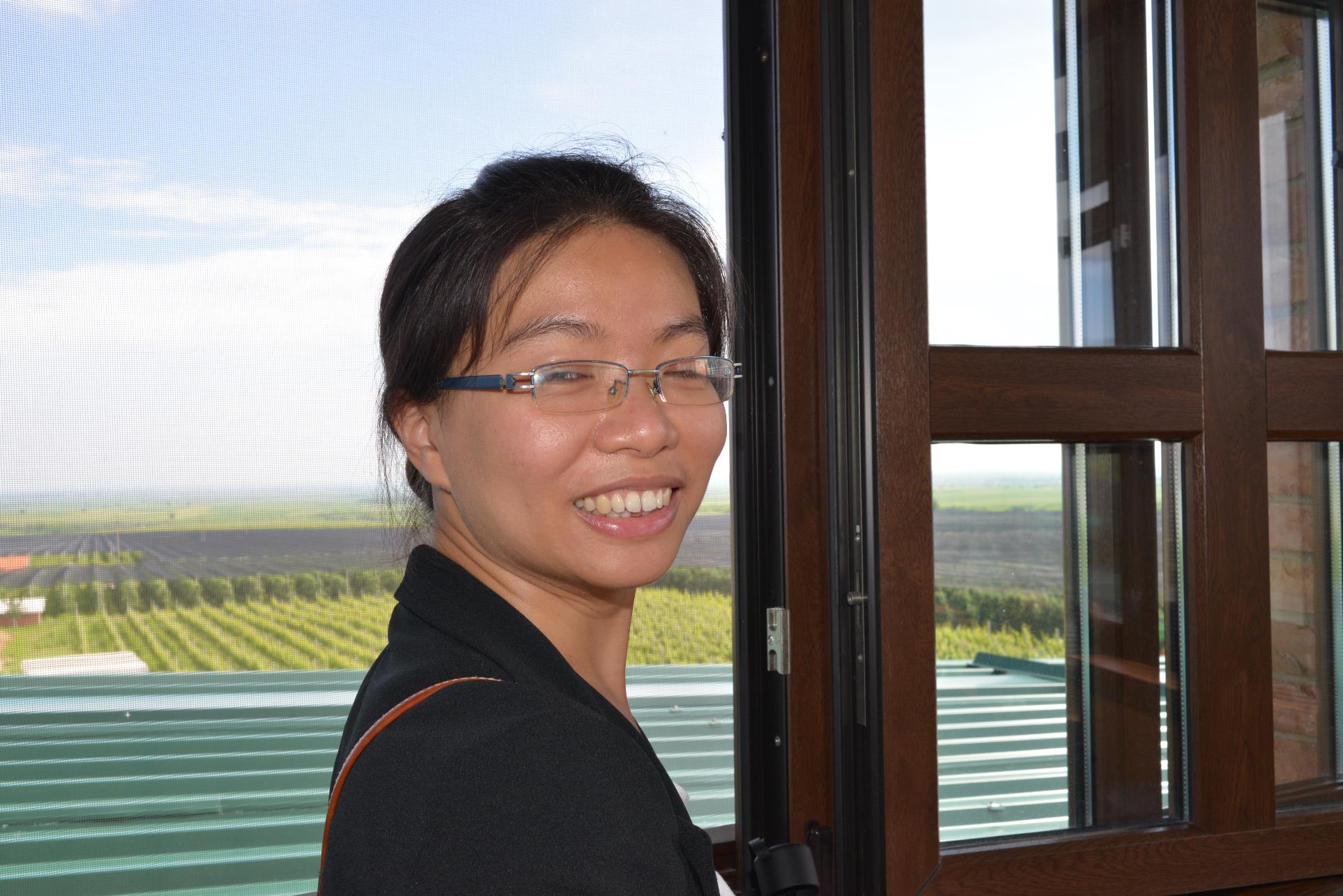 A person posing for the camera in front of a window

Description automatically generated