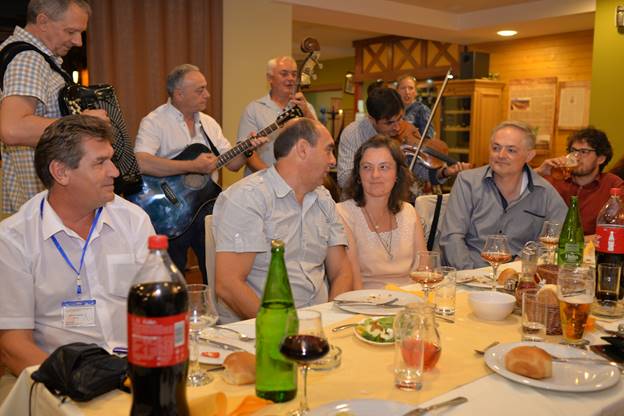 A group of people sitting at a table with wine glasses

Description generated with very high confidence