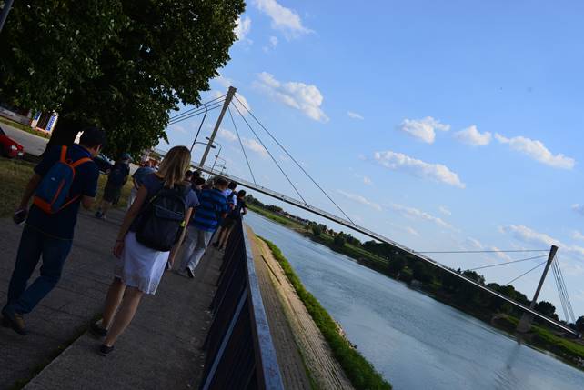 A group of people walking on a bridge

Description generated with high confidence