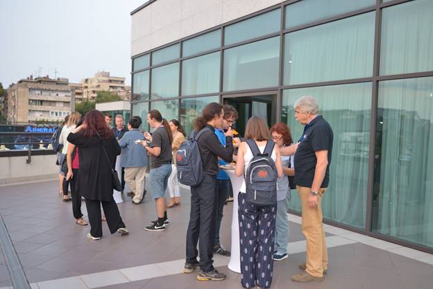 A group of people standing in front of a building

Description generated with very high confidence