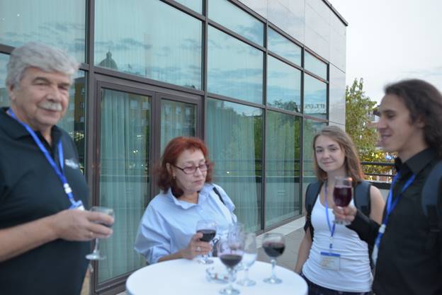 A group of people sitting at a table with wine glasses

Description generated with very high confidence