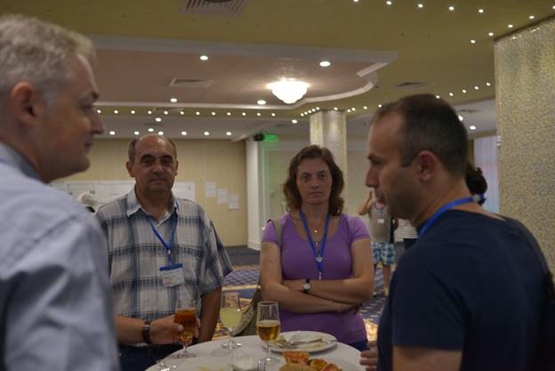 A group of people standing around a table

Description generated with very high confidence