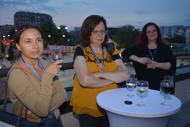 A group of people sitting at a table with wine glasses

Description generated with very high confidence