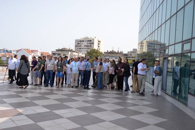 A group of people walking on a sidewalk

Description generated with very high confidence