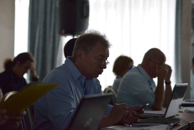 A group of people sitting at a table using a computer

Description generated with very high confidence