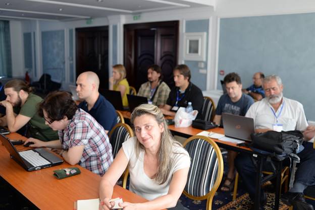 A group of people sitting at a table using a computer

Description generated with very high confidence