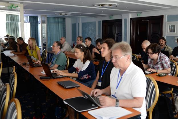 A group of people sitting at a table using a computer

Description generated with very high confidence