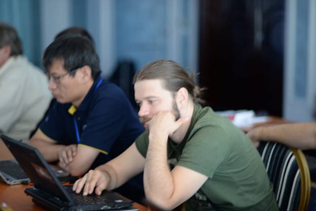 A group of people sitting at a table using a computer

Description generated with very high confidence