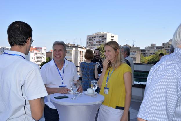 A group of people standing around a table

Description generated with very high confidence