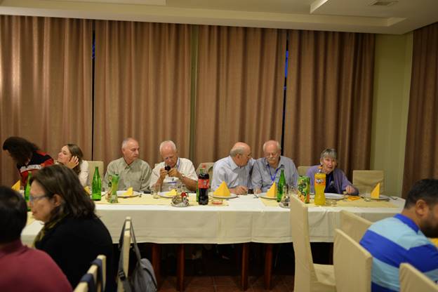 A group of people sitting at a table

Description generated with very high confidence