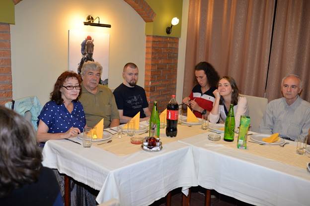 A group of people sitting at a table with wine glasses

Description generated with very high confidence