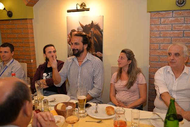 A group of people sitting at a table with wine glasses

Description generated with very high confidence