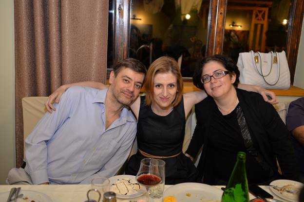 A group of people sitting at a dinner table posing for the camera

Description generated with very high confidence