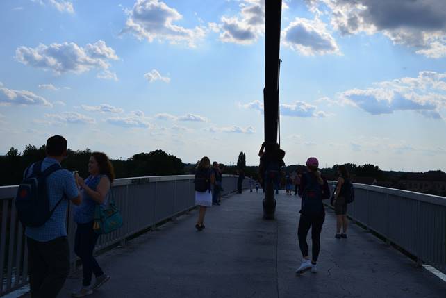 A group of people walking through a cloudy sky

Description generated with very high confidence