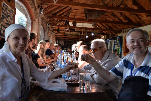 A group of people standing around a table

Description generated with very high confidence