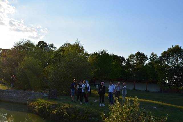 A group of people standing next to a river

Description generated with very high confidence