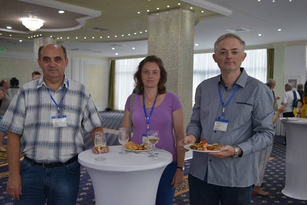 A group of people standing around a table

Description generated with very high confidence