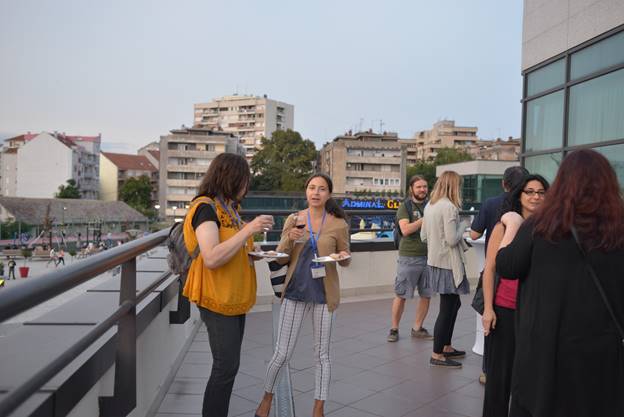 A group of people standing in front of a building

Description generated with very high confidence