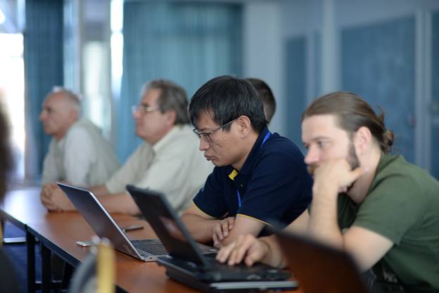 A group of people sitting at a table using a computer

Description generated with very high confidence