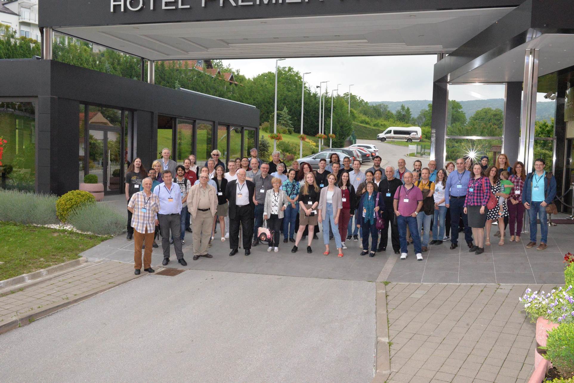 A group of people standing on a sidewalk

Description automatically generated