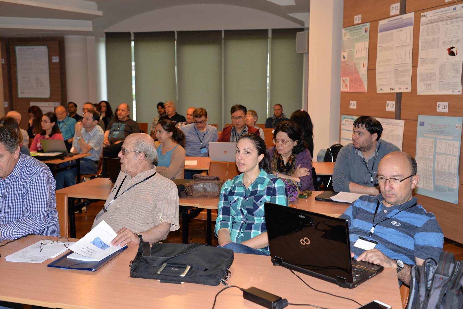 A group of people sitting at a table with a computer

Description automatically generated