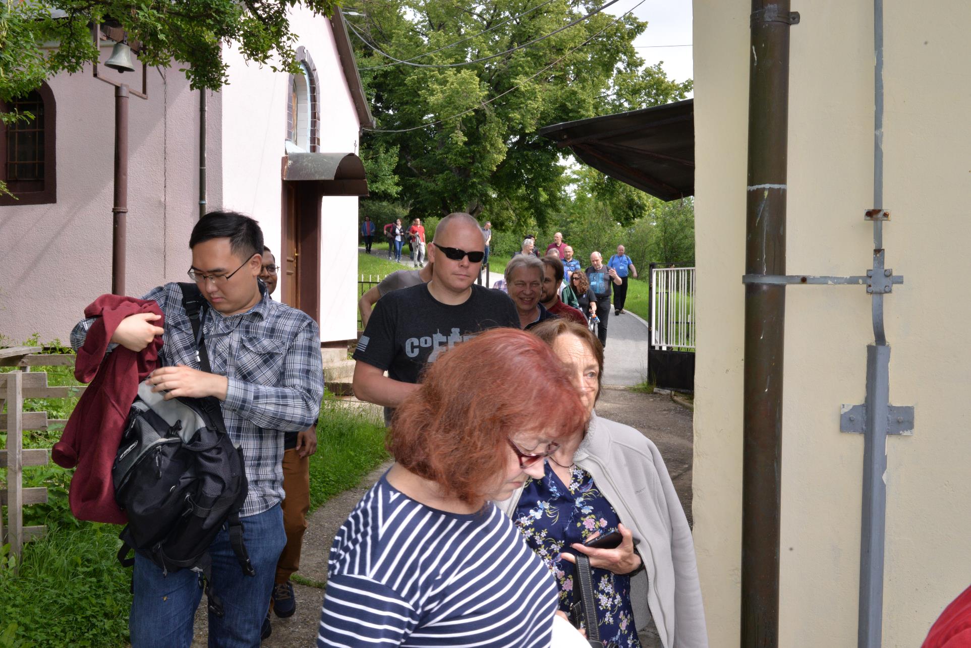 A group of people standing in front of a building

Description automatically generated