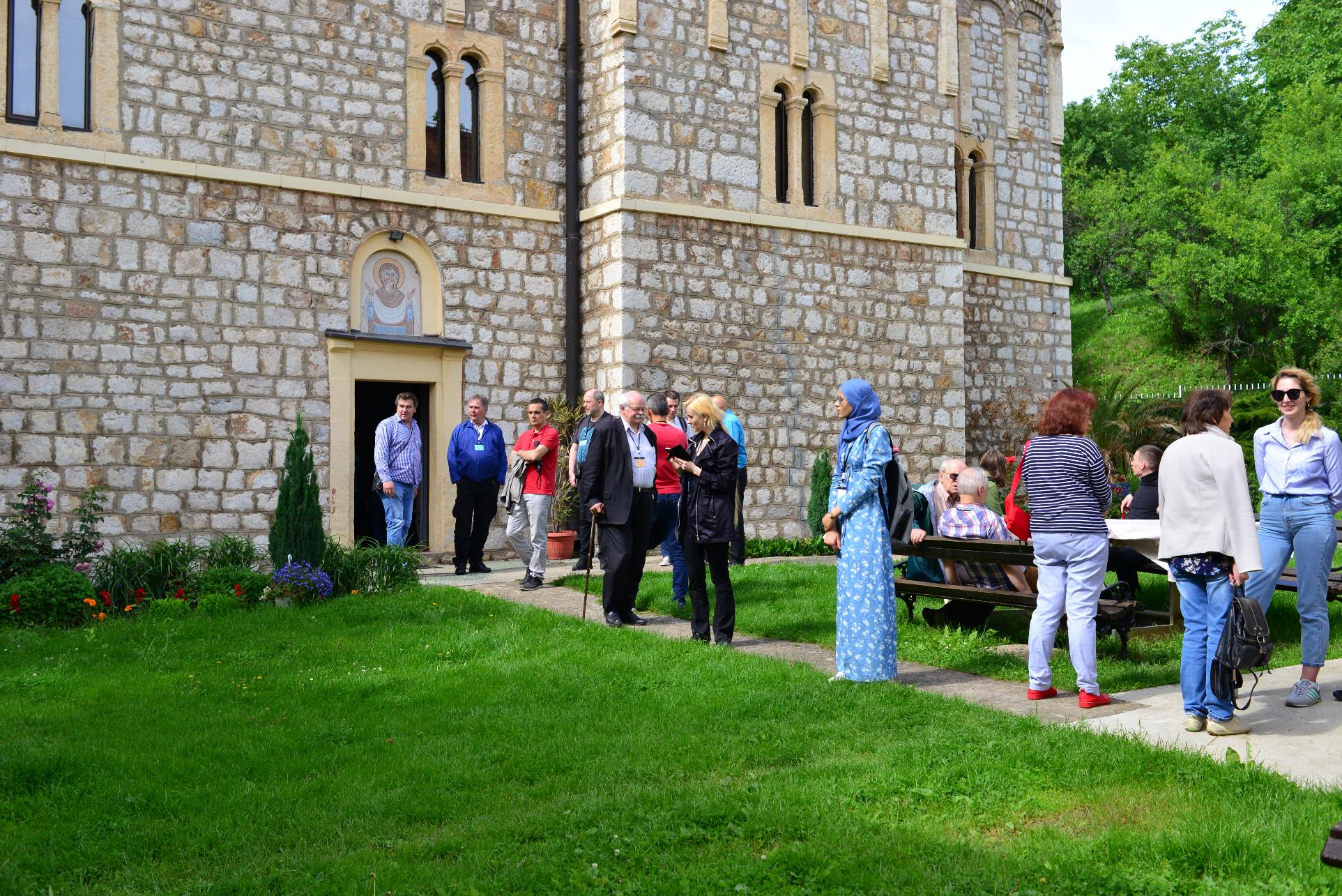 A group of people standing in front of a building

Description automatically generated