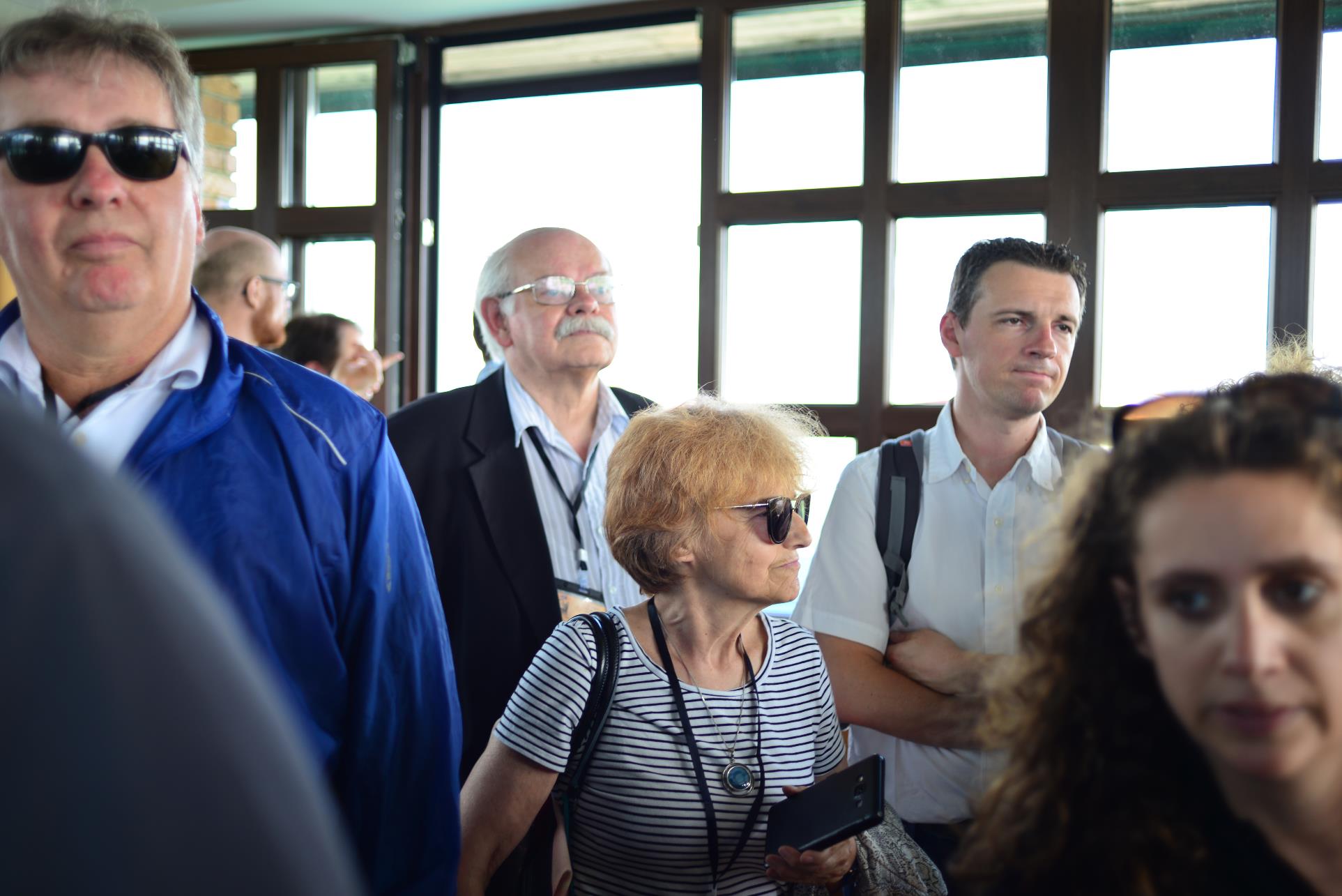 A group of people standing next to a window

Description automatically generated