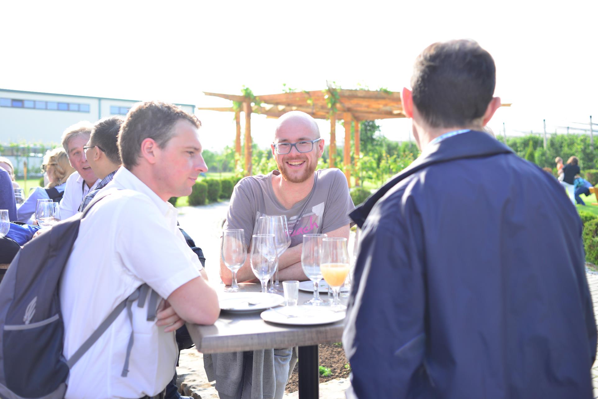 A group of people standing around a table

Description automatically generated