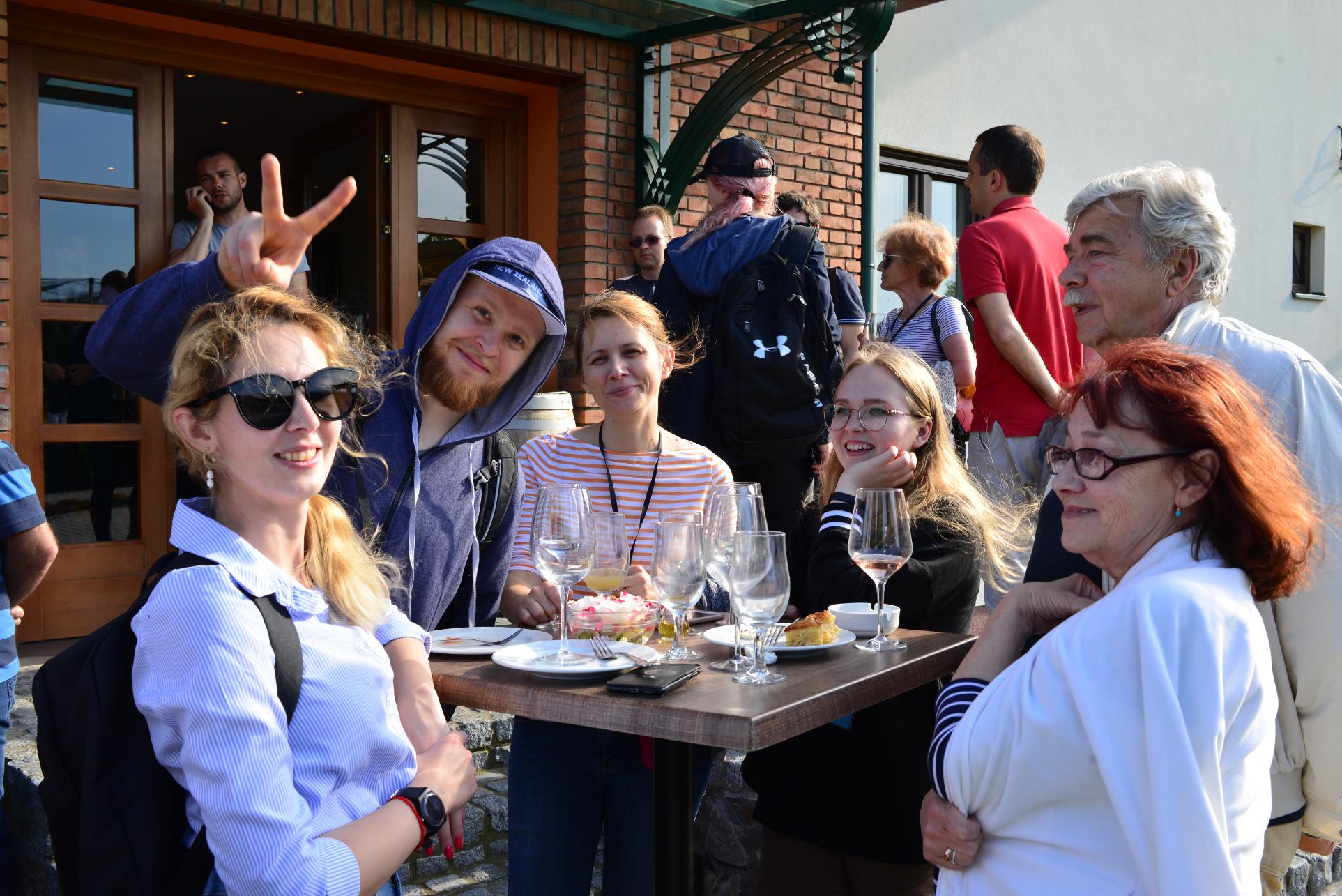 A group of people standing around a table

Description automatically generated