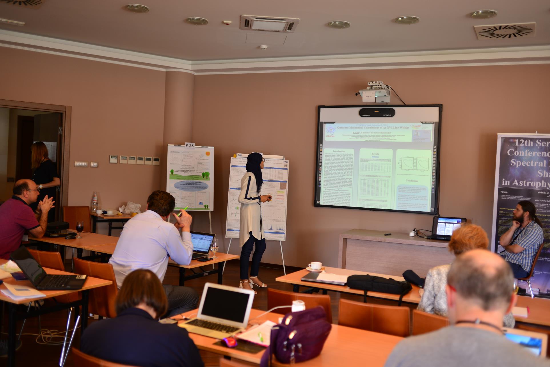 A group of people sitting at a table in front of a computer

Description automatically generated