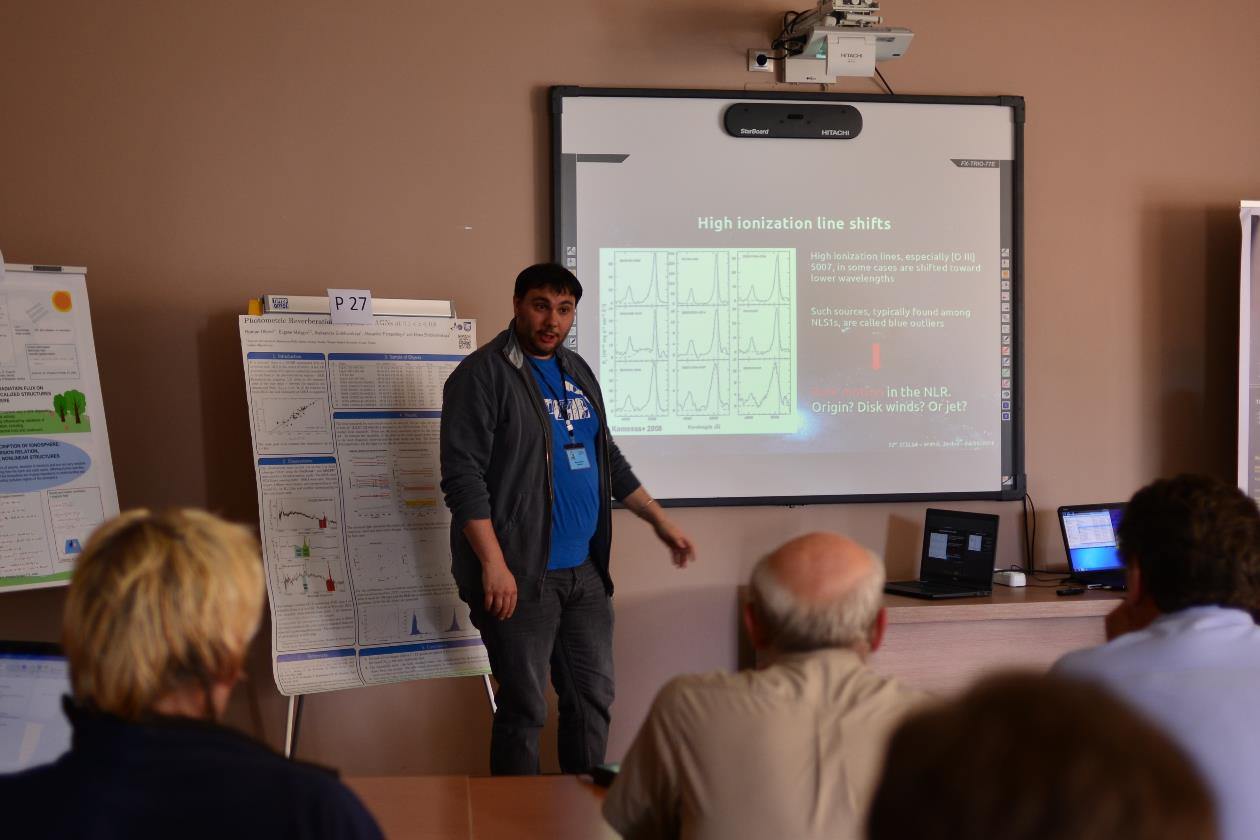 A group of people standing in front of a television

Description automatically generated